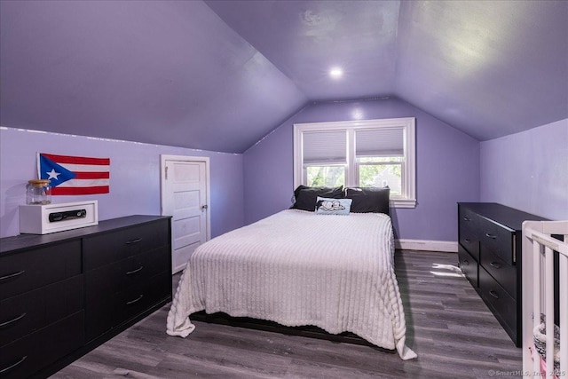bedroom with dark wood-style flooring, vaulted ceiling, and baseboards