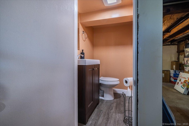 bathroom featuring toilet, vanity, and wood finished floors