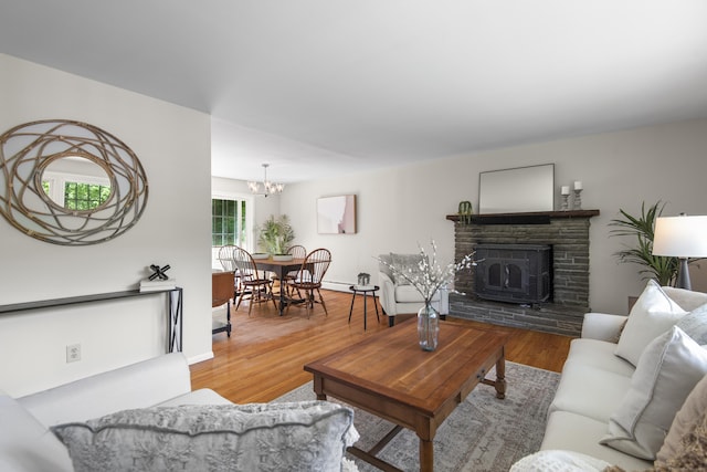 27 Scudder Rd, Newtown, CT 06470 - living area featuring a chandelier, wood finished floors, a fireplace with raised hearth, and baseboards