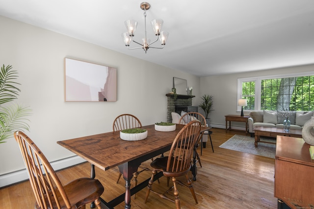 27 Scudder Rd, Newtown, CT 06470 - dining space with a chandelier, a fireplace, wood finished floors, and baseboard heating