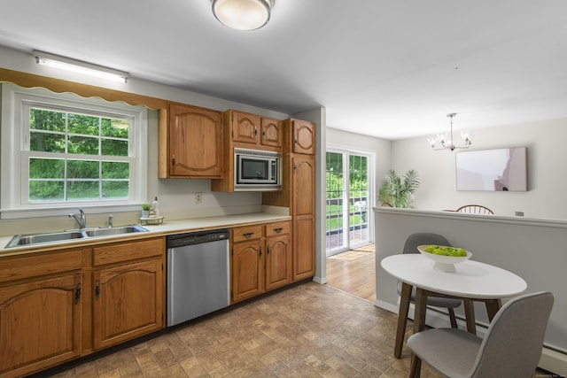 27 Scudder Rd, Newtown, CT 06470 - kitchen featuring appliances with stainless steel finishes, a sink, brown cabinetry, a chandelier, and light countertops