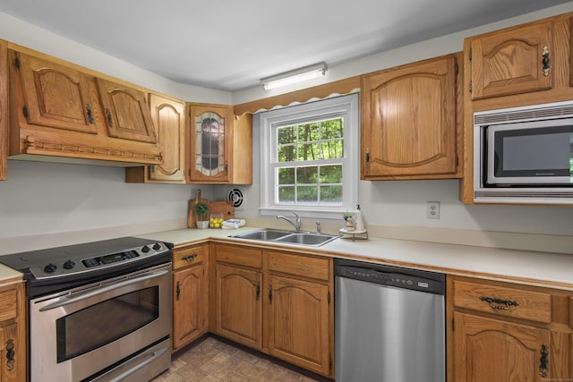 27 Scudder Rd, Newtown, CT 06470 - kitchen with stainless steel appliances, a sink, light countertops, and brown cabinetry