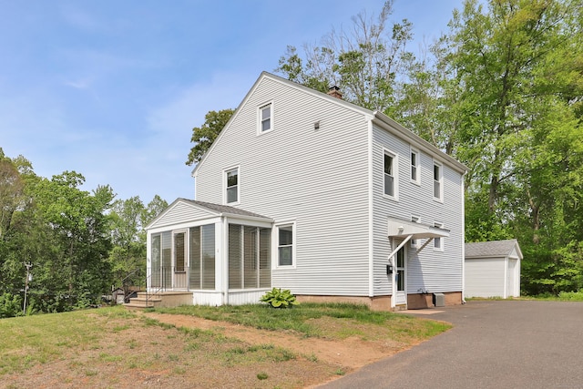 55 Dividend Rd, Rocky Hill, CT 06067 - view of home's exterior with a chimney, an outbuilding, a sunroom, and a detached garage