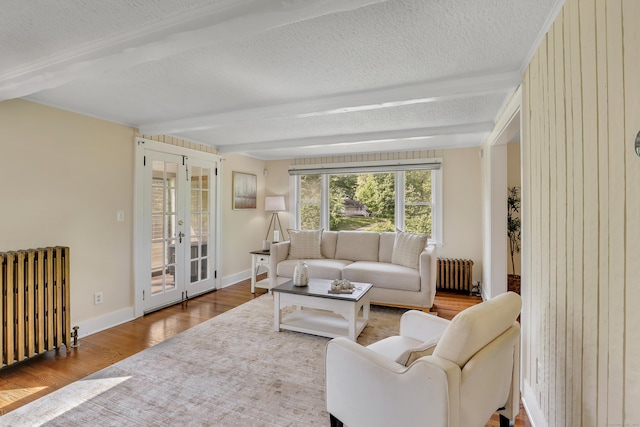 55 Dividend Rd, Rocky Hill, CT 06067 - living room with radiator, beamed ceiling, wood finished floors, french doors, and a textured ceiling