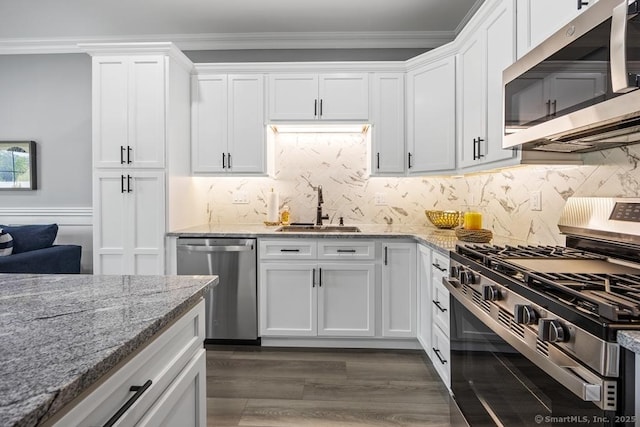 210 Munson Rd Unit 3-C, Wolcott, CT 06716 - kitchen featuring appliances with stainless steel finishes, white cabinets, light stone counters, dark wood-type flooring, and crown molding
