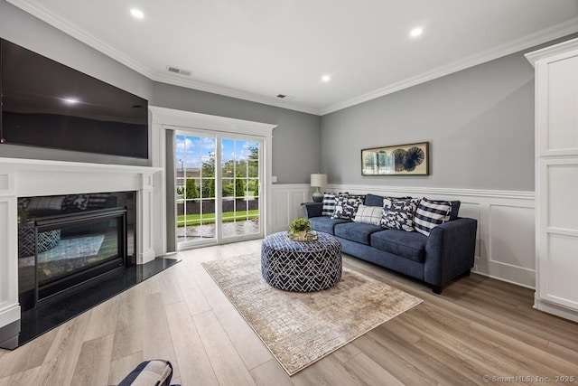 210 Munson Rd Unit 3-C, Wolcott, CT 06716 - living area with light wood-style flooring, wainscoting, a glass covered fireplace, recessed lighting, and crown molding