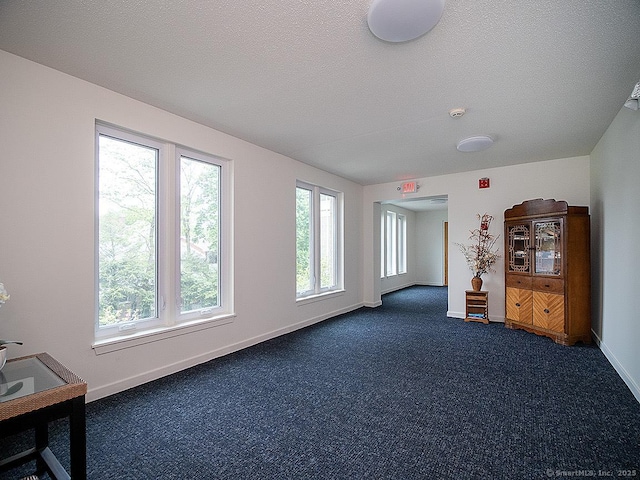 500 Prospect St Apt 3G, New Haven, CT 06511 - unfurnished living room with baseboards, a textured ceiling, and dark colored carpet