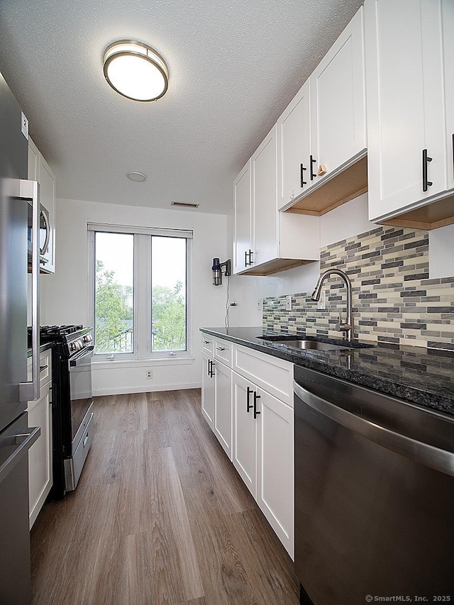 500 Prospect St Apt 3G, New Haven, CT 06511 - kitchen featuring stainless steel appliances, dark wood finished floors, a sink, backsplash, and white cabinetry