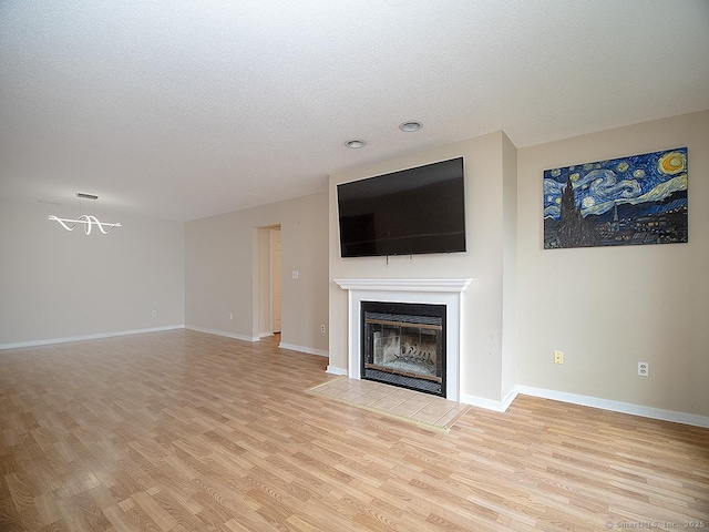 500 Prospect St Apt 3G, New Haven, CT 06511 - unfurnished living room featuring light wood-type flooring, a fireplace with flush hearth, a textured ceiling, baseboards, and recessed lighting