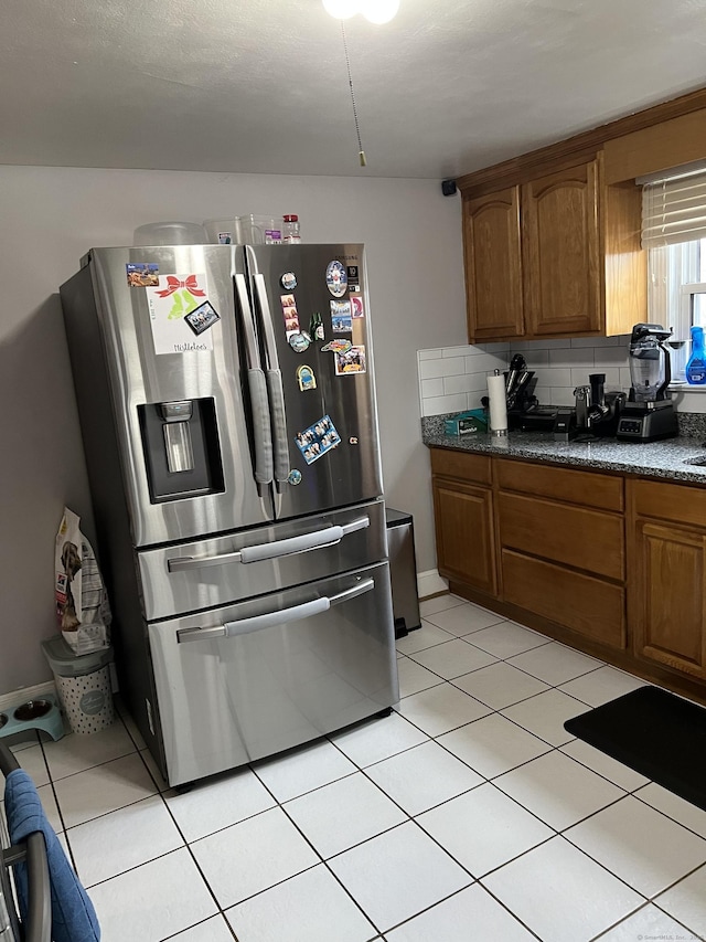 15 Michael Ave, East Hartford, CT 06111 - kitchen with stainless steel fridge, brown cabinets, dark countertops, and light tile patterned floors