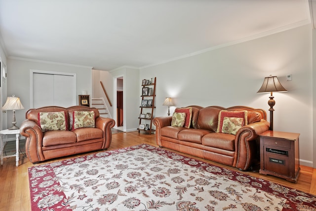 living area featuring ornamental molding, wood finished floors, and stairway