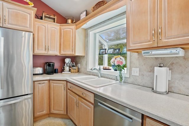 kitchen with stainless steel appliances, a sink, light brown cabinetry, light countertops, and lofted ceiling