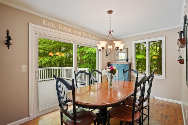 dining area with a chandelier, baseboards, ornamental molding, and light wood-style floors