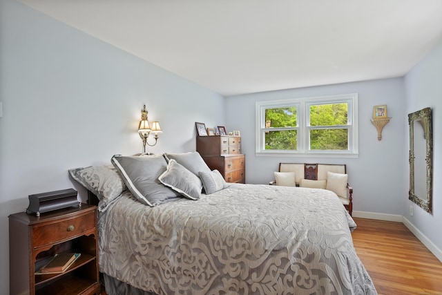 bedroom featuring wood finished floors and baseboards