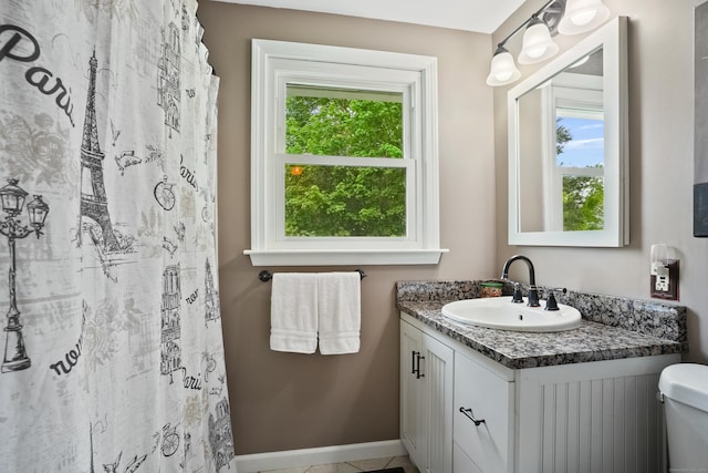 bathroom with vanity, baseboards, and toilet