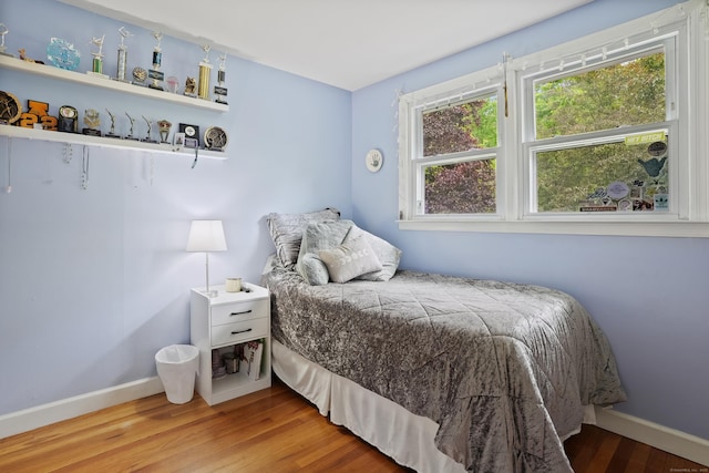 bedroom with wood finished floors and baseboards