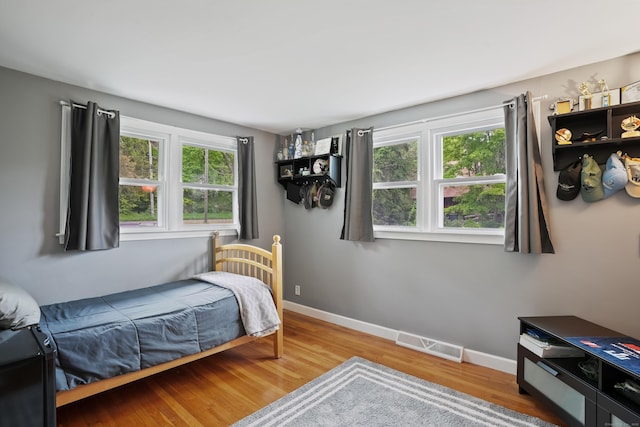 bedroom with wood finished floors and baseboards