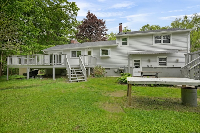 rear view of house featuring stairs, a chimney, a wooden deck, and a lawn