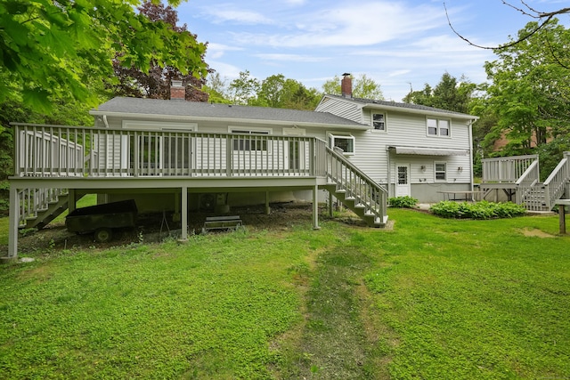 rear view of house featuring stairs, a chimney, and a lawn