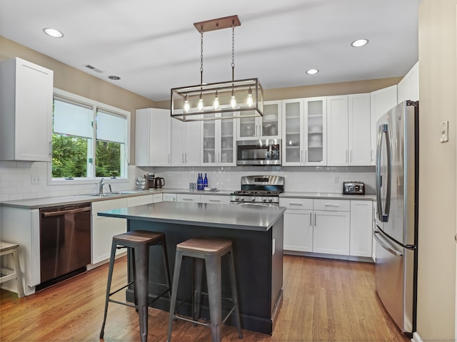 10 Wilton Hunt Rd, Wilton, CT 06897 - kitchen featuring appliances with stainless steel finishes, a kitchen breakfast bar, decorative backsplash, white cabinetry, and a sink