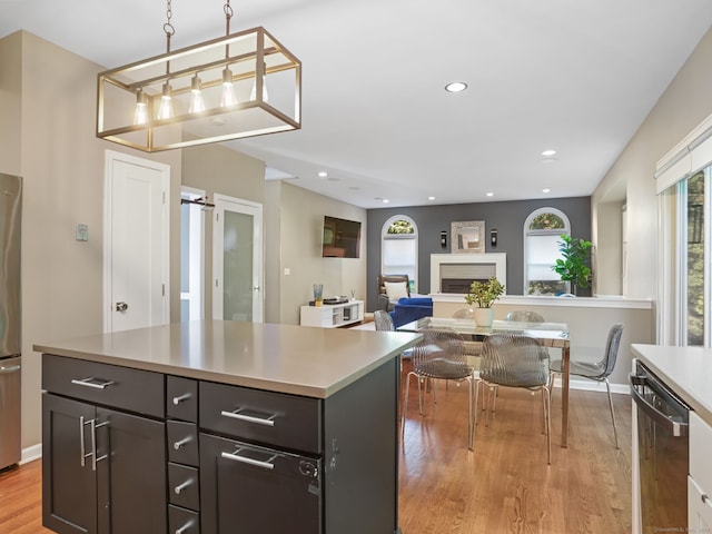 10 Wilton Hunt Rd, Wilton, CT 06897 - kitchen featuring stainless steel appliances, light wood-type flooring, light countertops, a fireplace, and decorative light fixtures