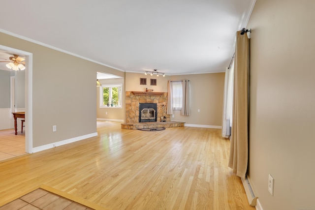 31 Hemlock Dr, Southington, CT 06489 - unfurnished living room with a stone fireplace, crown molding, ceiling fan, light wood-style flooring, and baseboards