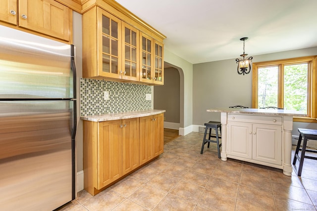 179 Parker Rd, Somers, CT 06071 - kitchen with freestanding refrigerator, a kitchen bar, arched walkways, light countertops, and backsplash