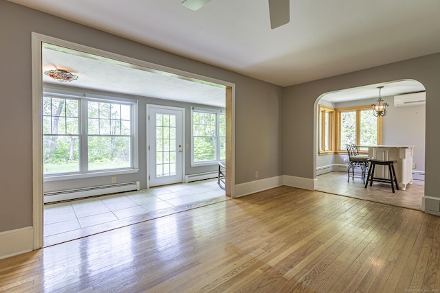 179 Parker Rd, Somers, CT 06071 - unfurnished living room featuring baseboard heating, arched walkways, and a wall mounted air conditioner