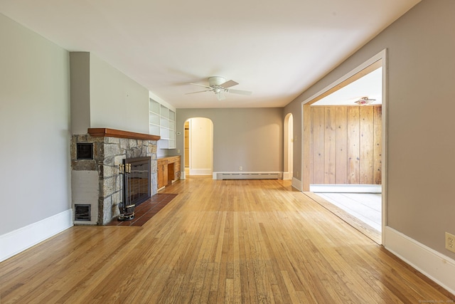 179 Parker Rd, Somers, CT 06071 - unfurnished living room with baseboard heating, arched walkways, light wood-style floors, and a fireplace