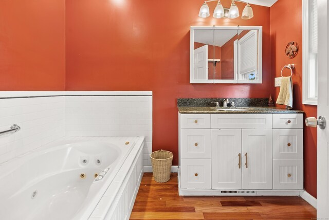 28 Edmund St, Stratford, CT 06614 - full bath with wood finished floors, a whirlpool tub, vanity, and baseboards