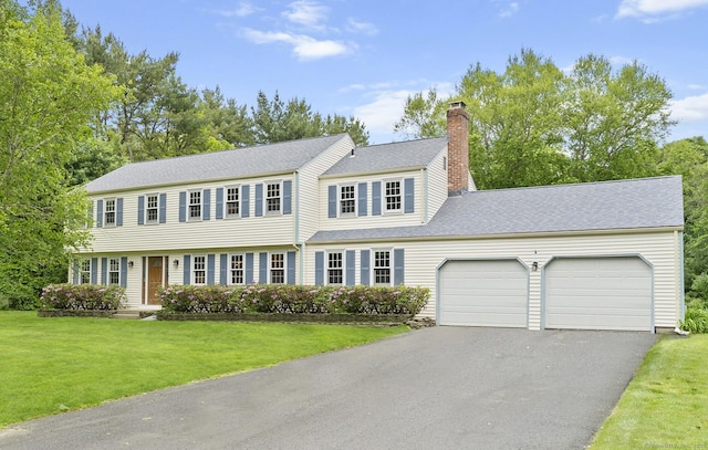 8 Michael Rd, Simsbury, CT 06070 - colonial house featuring asphalt driveway, an attached garage, a chimney, a front yard, and a shingled roof