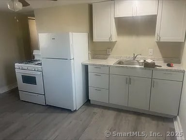 131 W Main St, Southington, CT 06479 - kitchen featuring white appliances, wood finished floors, light countertops, and ceiling fan