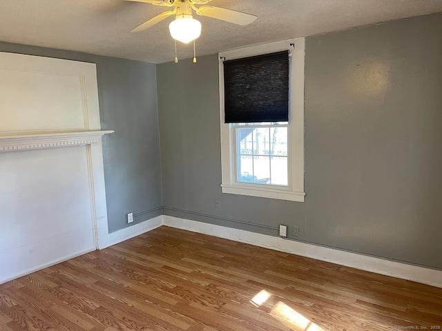 131 W Main St, Southington, CT 06479 - unfurnished bedroom with wood finished floors, a textured ceiling, baseboards, and a ceiling fan