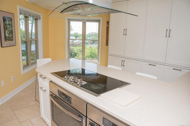 58 Quarry Dock Rd Unit 58, Branford, CT 06405 - kitchen with oven, black electric stovetop, light countertops, white cabinetry, and light tile patterned floors