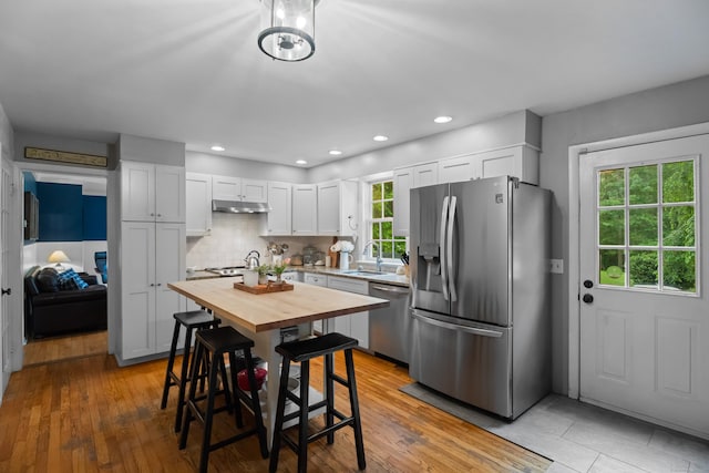 57 Elm Ridge Rd, Stonington, CT 06379 - kitchen featuring stainless steel appliances, wooden counters, under cabinet range hood, white cabinetry, and tasteful backsplash