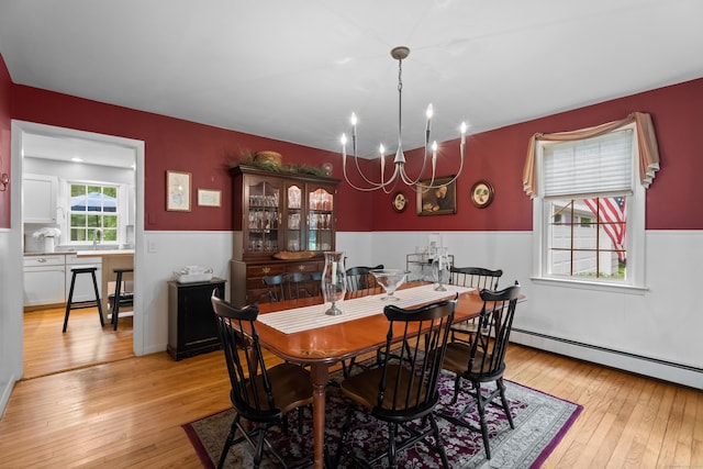 57 Elm Ridge Rd, Stonington, CT 06379 - dining room featuring a chandelier, light wood finished floors, a wainscoted wall, and a baseboard heating unit