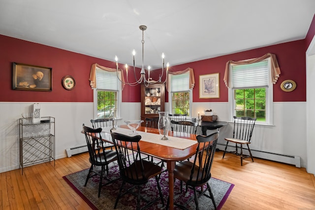 57 Elm Ridge Rd, Stonington, CT 06379 - dining space featuring baseboard heating, a chandelier, plenty of natural light, hardwood / wood-style floors, and a wainscoted wall