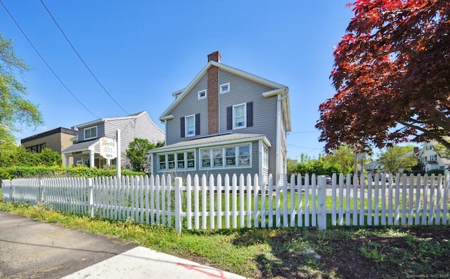 189 E Ave, Norwalk, CT 06855 - view of front of property featuring a chimney and a fenced front yard