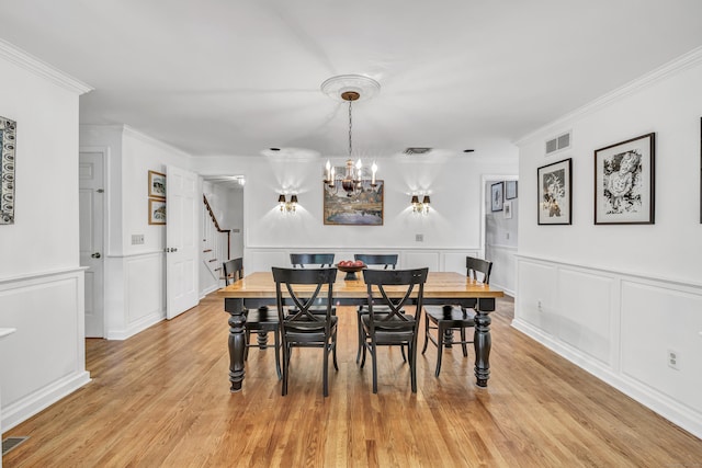 73 Golden Hill St, Trumbull, CT 06611 - dining room featuring stairway, a chandelier, light wood-style flooring, ornamental molding, and wainscoting