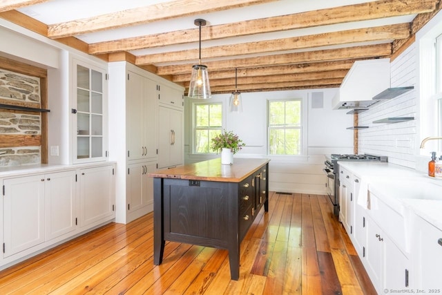 99 Sharon Mountain Rd, Sharon, CT 06069 - kitchen featuring high end stainless steel range oven, white cabinetry, light wood-type flooring, butcher block counters, and beam ceiling
