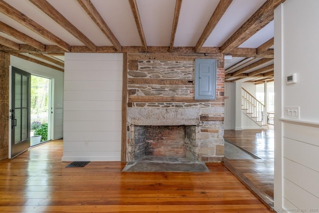 99 Sharon Mountain Rd, Sharon, CT 06069 - unfurnished living room with wood-type flooring, beam ceiling, a fireplace, stairway, and electric panel