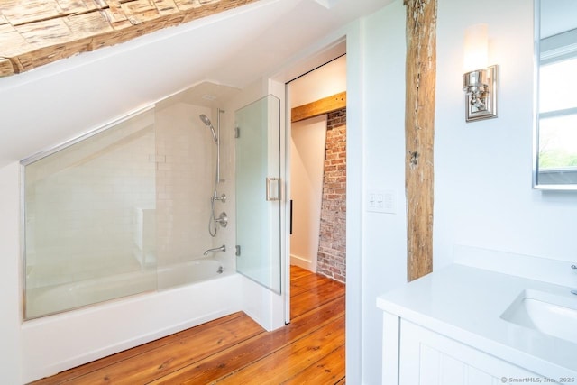 99 Sharon Mountain Rd, Sharon, CT 06069 - full bath featuring wood finished floors, combined bath / shower with glass door, vanity, brick wall, and vaulted ceiling