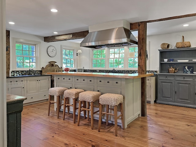 114 Ruscoe Rd, Wilton, CT 06897 - kitchen featuring island exhaust hood, light wood-type flooring, recessed lighting, and a kitchen bar