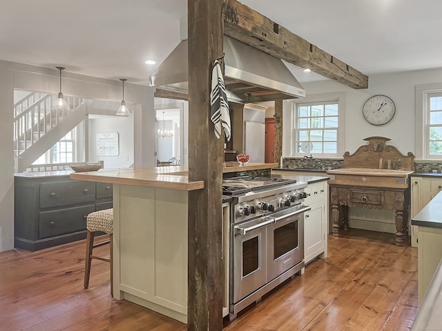 114 Ruscoe Rd, Wilton, CT 06897 - kitchen with double oven range, range hood, light wood-style flooring, a breakfast bar area, and a chandelier