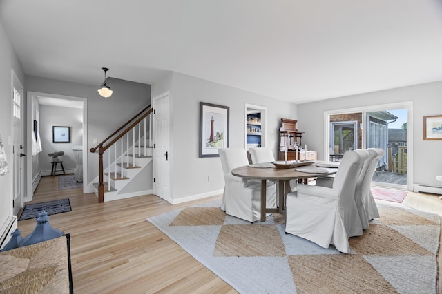 410 Noank Rd, Groton, CT 06355 - dining space with stairs, a baseboard radiator, baseboards, and light wood-type flooring