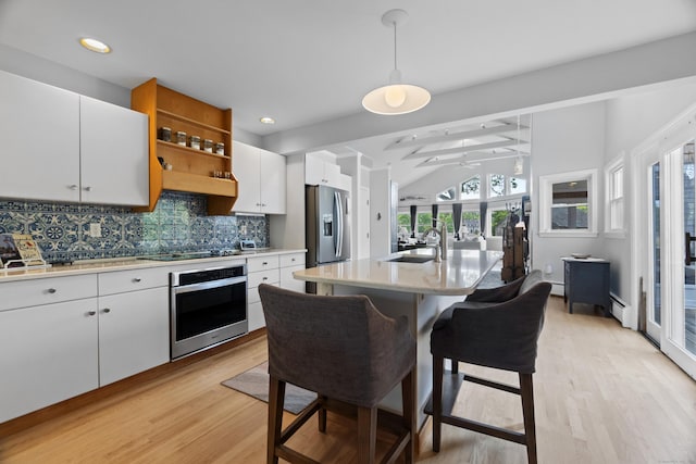 410 Noank Rd, Groton, CT 06355 - kitchen with stainless steel appliances, light wood finished floors, tasteful backsplash, white cabinets, and light countertops