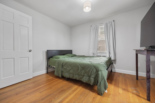 bedroom with light wood finished floors and baseboards