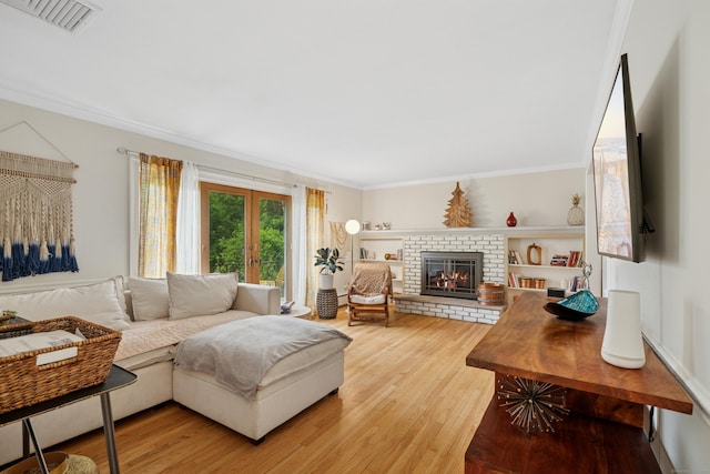 14 Button Rd, Shelton, CT 06484 - living area featuring light wood finished floors, ornamental molding, a brick fireplace, and french doors
