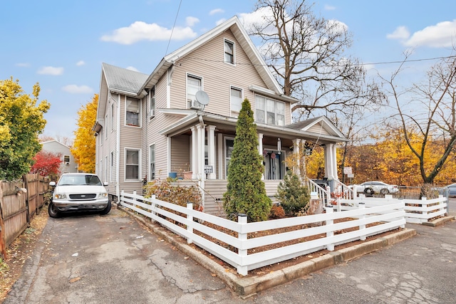 56 Gem Ave, Bridgeport, CT 06606 - view of front of home with covered porch, a fenced front yard, and asphalt driveway