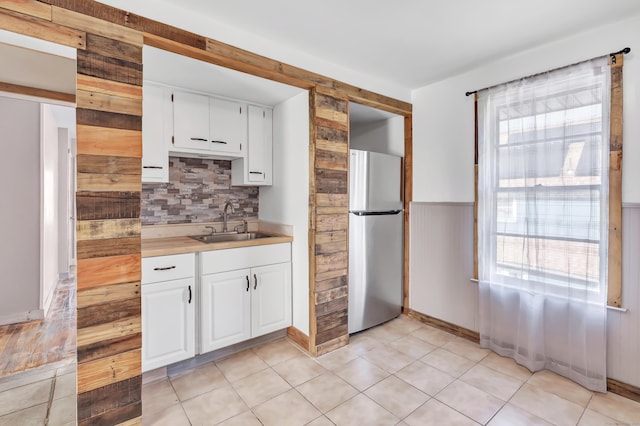 56 Gem Ave, Bridgeport, CT 06606 - kitchen with freestanding refrigerator, a sink, tasteful backsplash, white cabinetry, and light countertops
